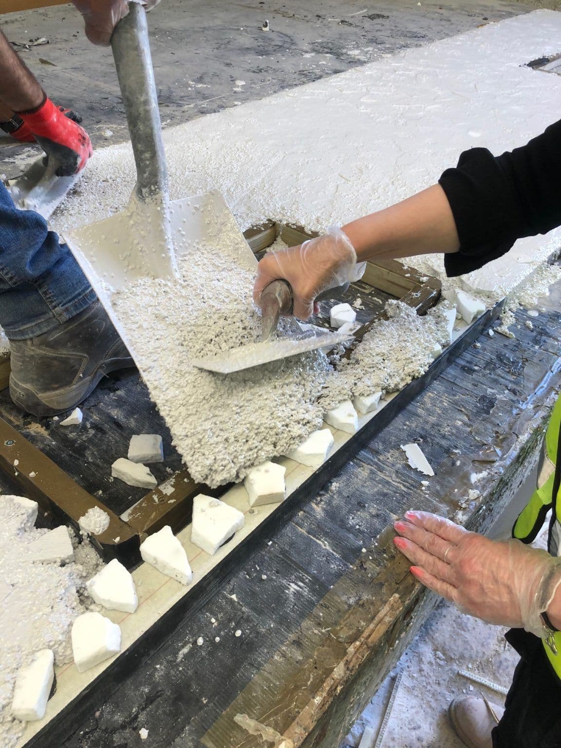 Mains composant un mélange de terrazzo sur un chantier